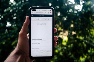 A person uses ChatGPT on a smartphone outdoors, showcasing technology in daily life.