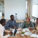 A diverse group of professionals engaging in a productive meeting in a contemporary office space.