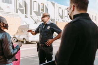 A police officer interacting with civilians during a peaceful protest in an urban setting.