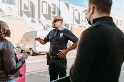 A police officer interacting with civilians during a peaceful protest in an urban setting.
