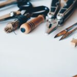 A selection of artisan tools and handmade crafts displayed on a white desk, perfect for creative projects.