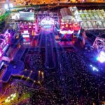 Aerial view of a vibrant music festival in Serpong, Indonesia with crowds and stage lights.