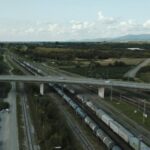 Freight train with containers traveling under a bridge in Offenburg, Germany.