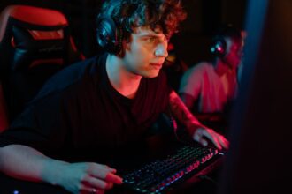 A dedicated gamer immersed in a gaming session with colorful lighting and headphones.