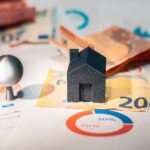 Conceptual image of real estate and finance involving euro currency and data charts, symbolizing investment.