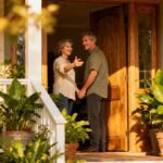 Paar steht glücklich vor seinem Haus