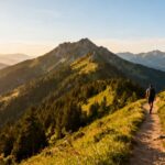 Wanderer auf einem Bergpfad mit Wäldern und Gipfeln.