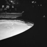People swimming in a pool at night