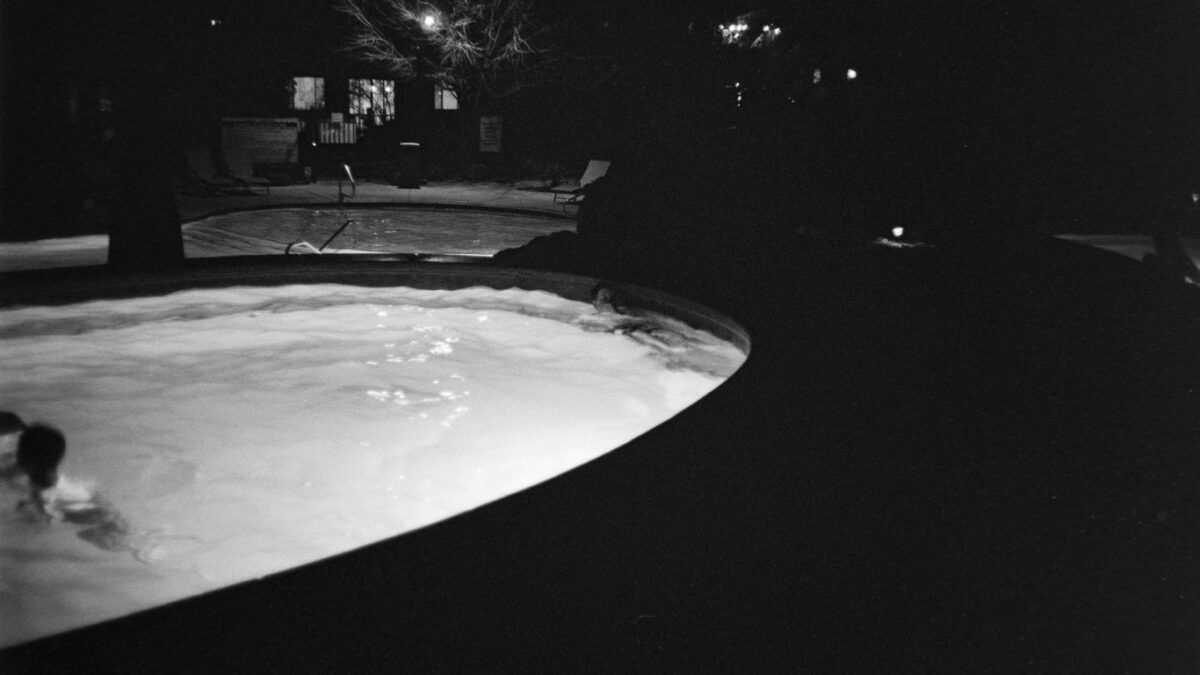 People swimming in a pool at night
