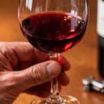 Glas Rotwein mit Flasche und Korkenzieher