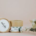 Organic skincare packaging with eucalyptus on a pastel background.