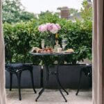 Charming outdoor table with peonies and wine, perfect for a summer brunch.