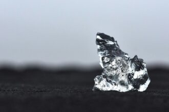 a piece of ice sitting on top of a black surface