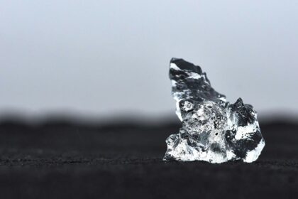 a piece of ice sitting on top of a black surface