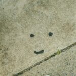A smiley face is drawn on a grungy surface.