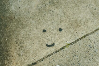 A smiley face is drawn on a grungy surface.