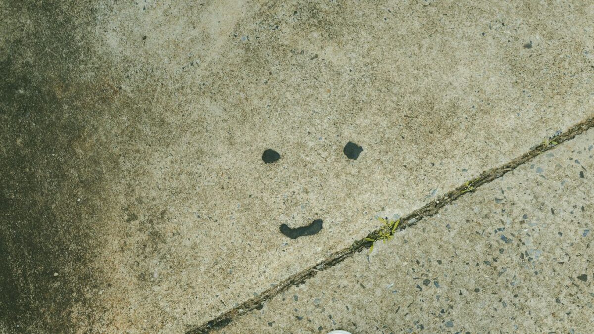 A smiley face is drawn on a grungy surface.