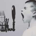 boy singing on microphone with pop filter