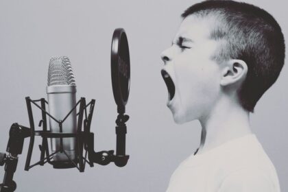 boy singing on microphone with pop filter