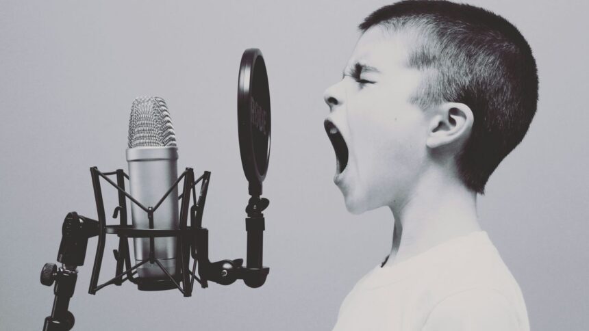 boy singing on microphone with pop filter